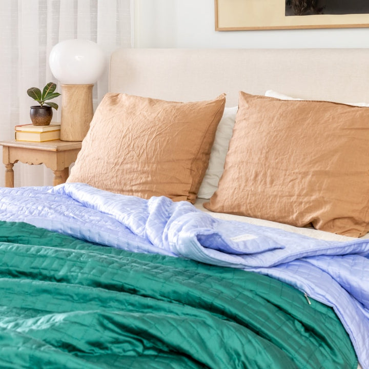 A couple Gravity Weighted Cooling Blankets laying on a bed - #color_forest-green