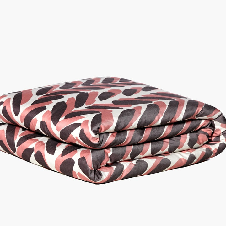 Pink and brown weighted blanket folded against a white background