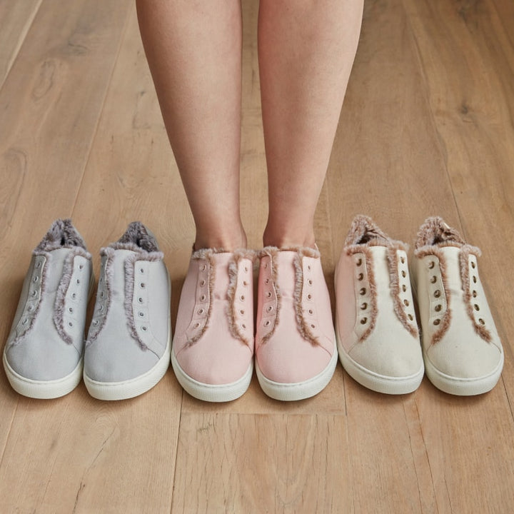 3 pairs of slippers in different colors placed in a row with a person wearing the pair in the center #color_grey