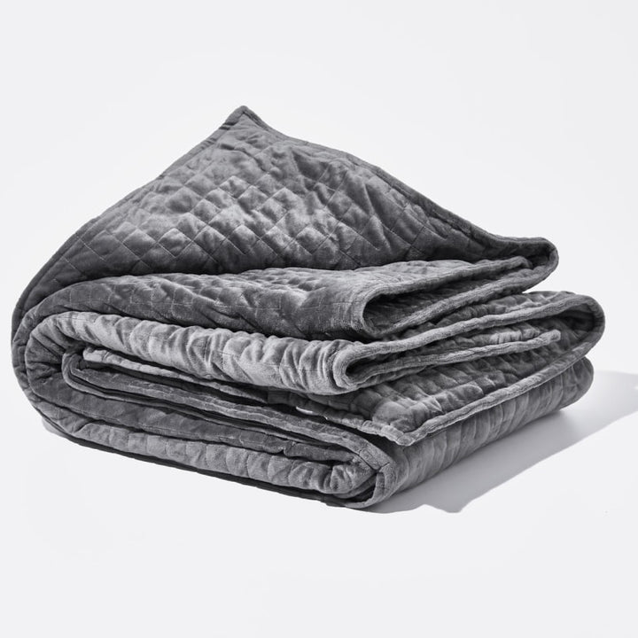 Original weighted blanket by Gravity in a plush grey fabric folded against a white backdrop - #color_grey
