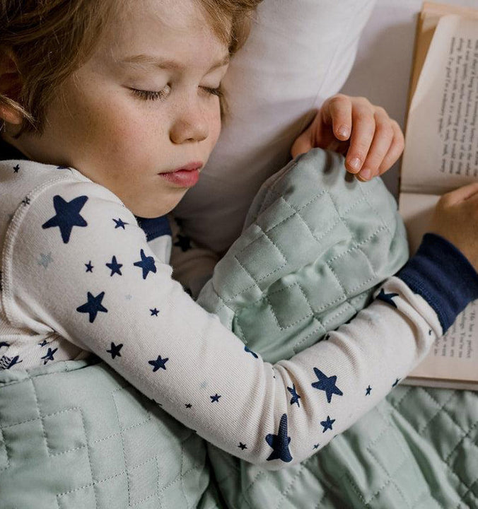 a child sleeping under a weighted blanket