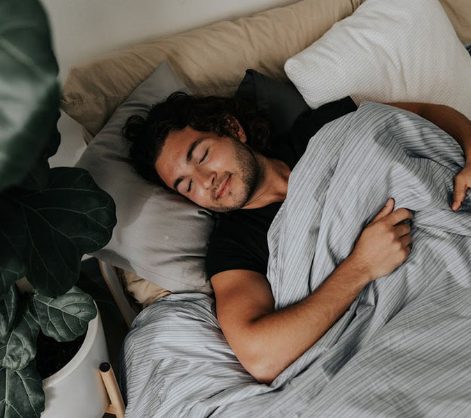 a man sleeping under a grey weighted