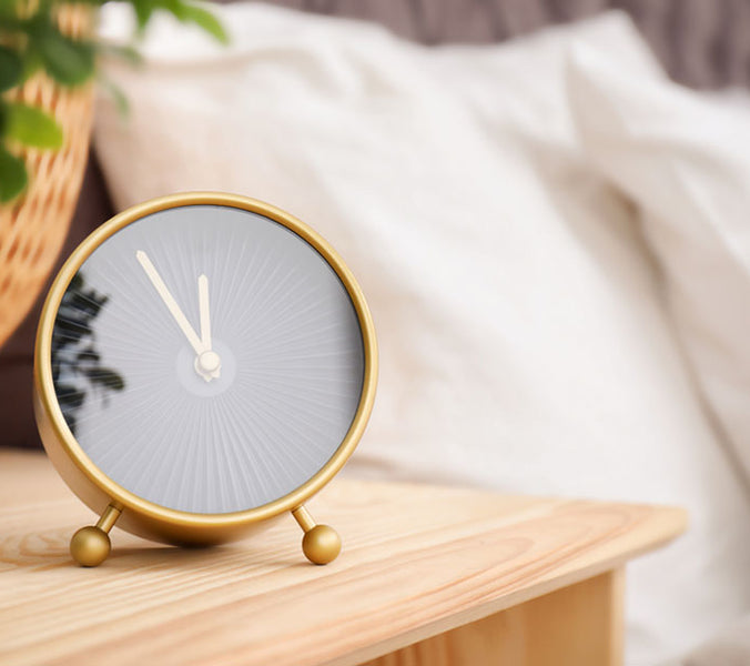 analog alarm clock on table near bedroom