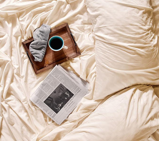 breakfast tray and newspaper on bed