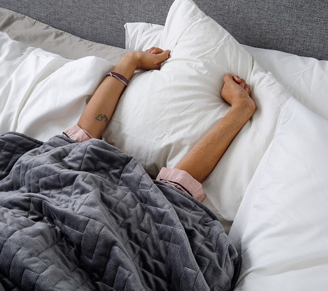 hands stretching out in bed