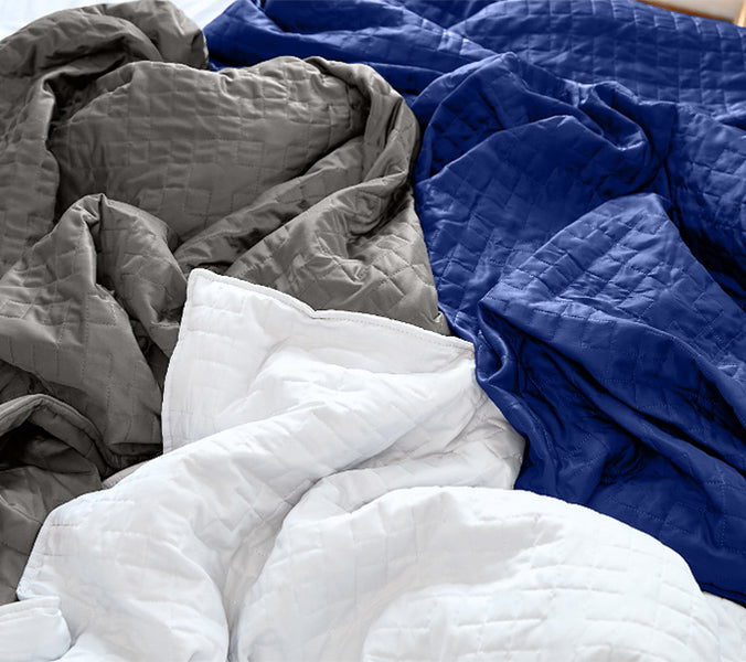 three weighted blankets in a pile