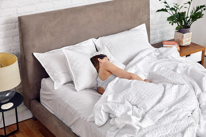 a woman asleep in bed with a weighted blanket