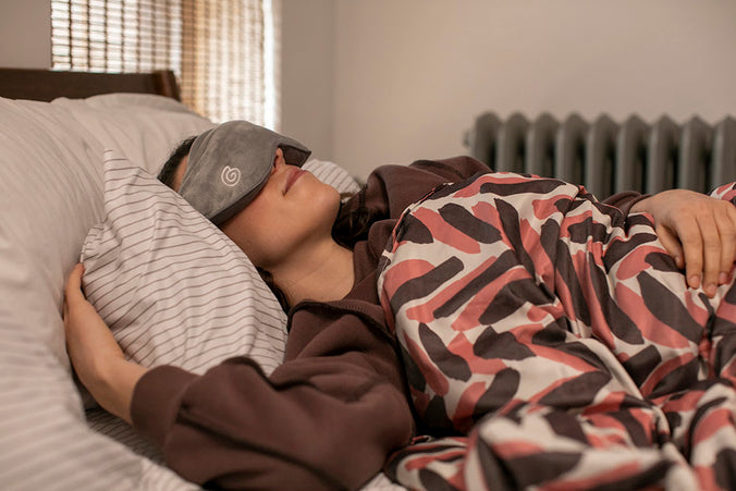 a woman sleeping while wearing a weighted mask